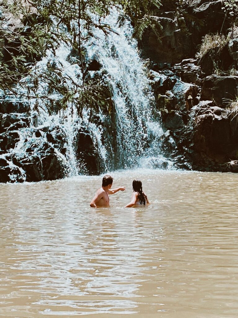 People swimming in Waterfall at The Kingfisher Lodge