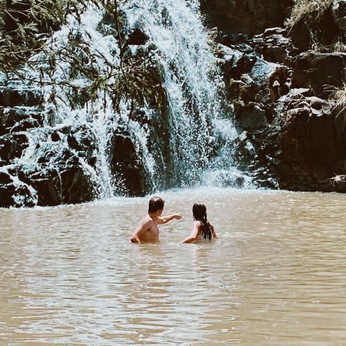 People swimming in Waterfall at The Kingfisher Lodge